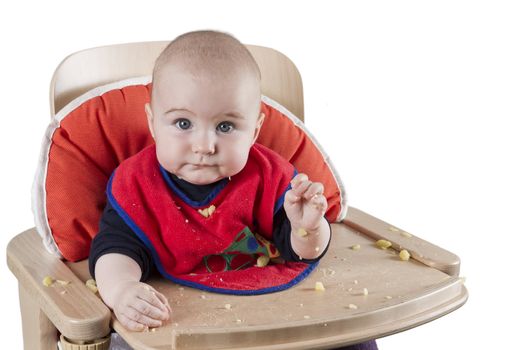 toddler eating potatoes in highchair