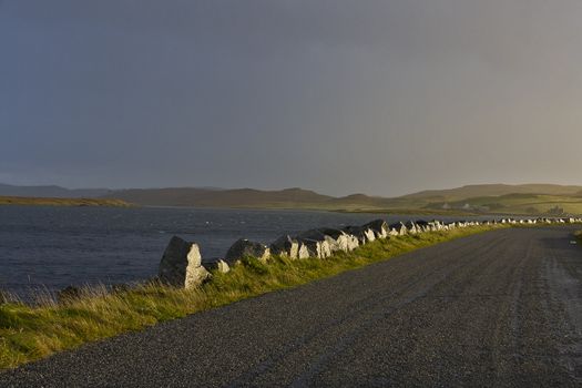 lonely road at loch in scotland in evening light