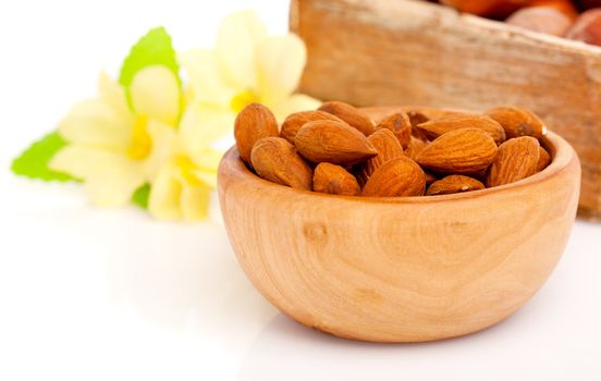 Dried almonds with flowers in the wooden bowl.