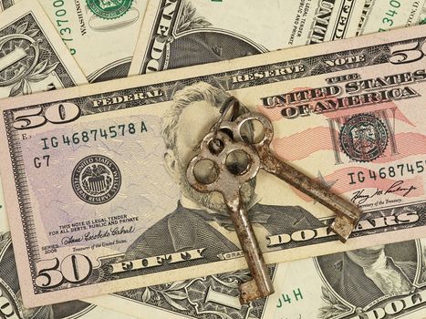 Two metal keys on a dollar banknotes backgroun.