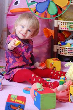 Baby girl in nursery playing toys