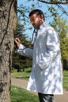 doctor with stetoscope listening to the heart of trees