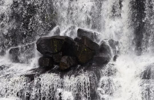 rocks in the middle of the waterfall