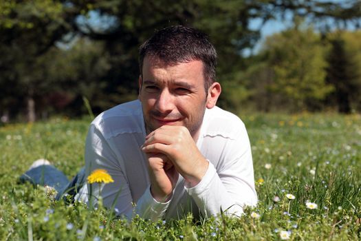 man lying on the grass in a park in spring