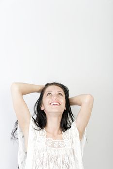 Young woman with long dark hair holding her hands around her head