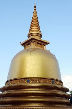 Historic golden stupa against blue the sky