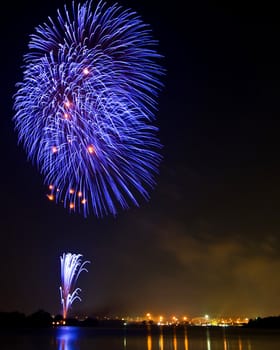 Tree Blue Fireworks at lake on King Birthday Festival and Holiday in Thailand.