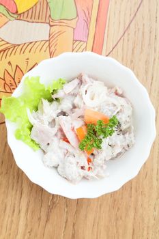 salad in white dish and wooden background