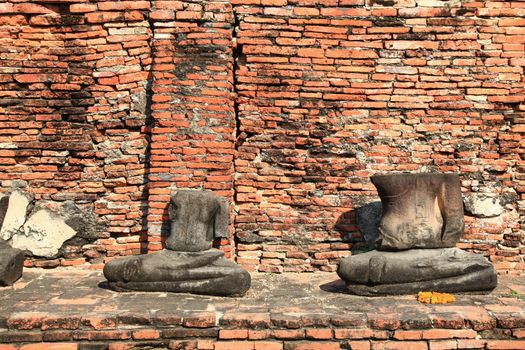 headless buddha statue in temple ruin wall, bangkok thailand