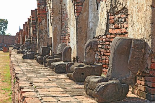 perspective of headless buddha statue in temple ruin wall, bangkok thailand