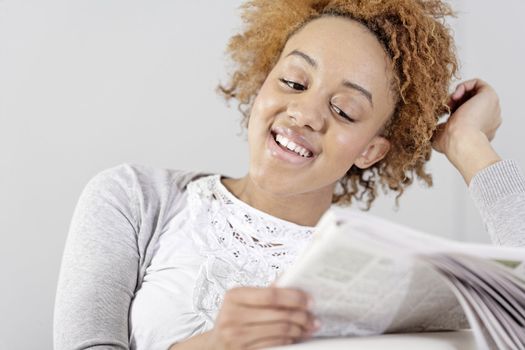 Beautiful young black woman enjoying a newspaper