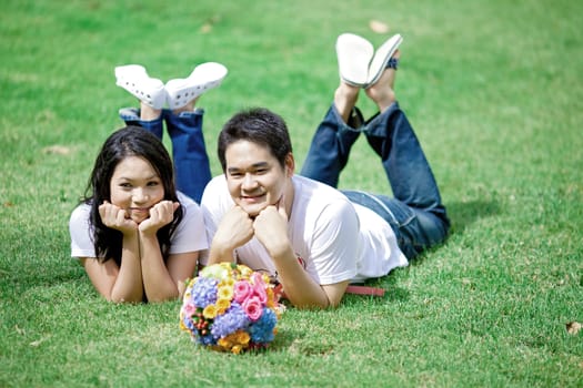 young couple laying on grass together
