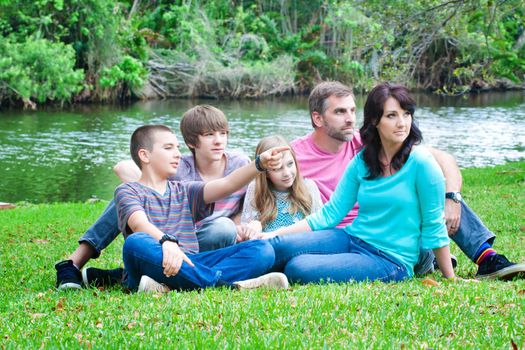 Portrait of a family sitting on a grass in the park