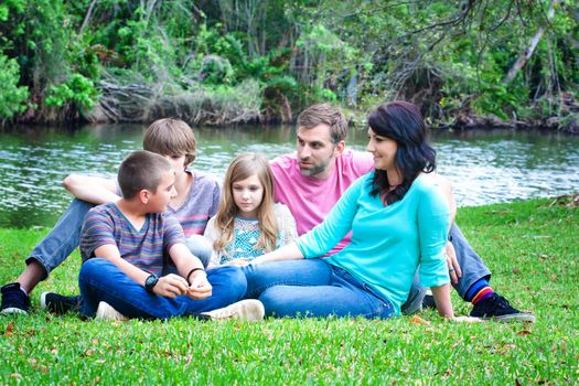 Portrait of a family sitting on a grass in the park