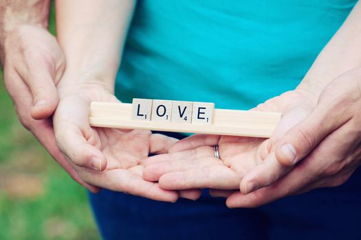 holding hands with the words love in the park