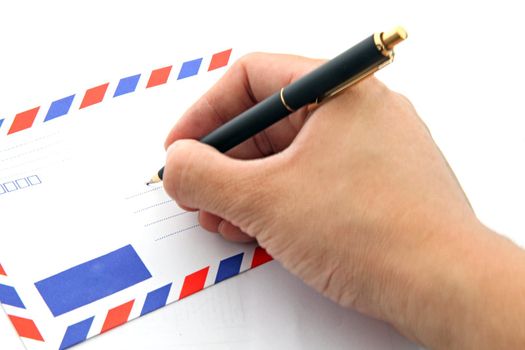 perspective of hand writing address on air mail envelope