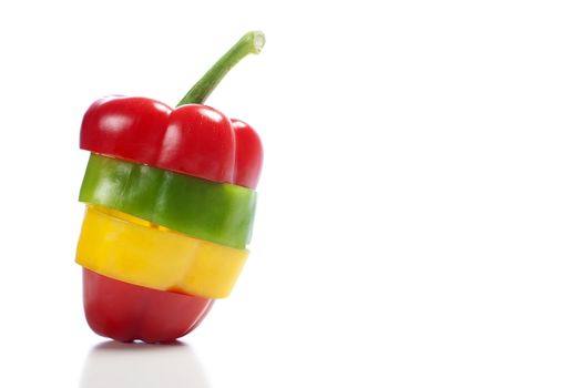 Red Yellow and Green peppers sliced and mixed up to look like one pepper on isolated white background