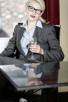 Attractive business woman in a wine bar waiting for a client or meeting.