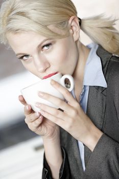 professional business woman drinking a mug of coffee at work.