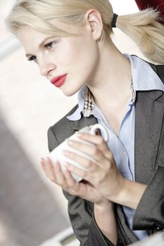 professional business woman drinking a mug of coffee at work.