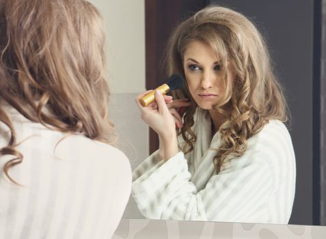 The young beautiful girl does makeup