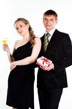 Portrait of a beautiful young couple with glasses of wine and a gift box with a red bow