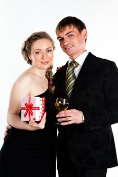 Portrait of a beautiful young couple with glasses of wine and a gift box with a red bow