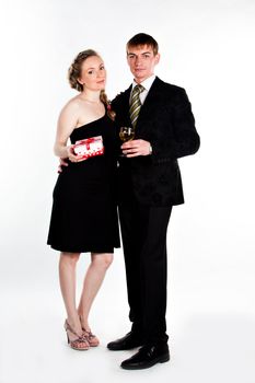 Portrait of a beautiful young couple with glasses of wine and a gift box with a red bow
