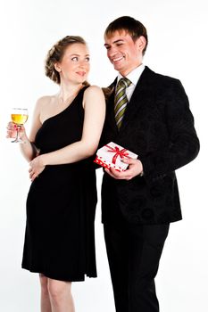 Portrait of a beautiful young couple with glasses of wine and a gift box with a red bow