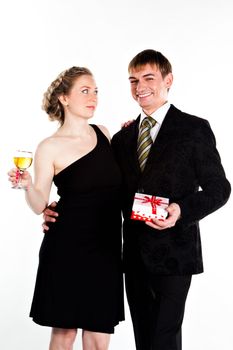 Portrait of a beautiful young couple with glasses of wine and a gift box with a red bow