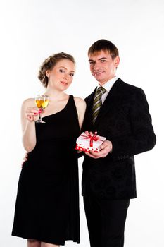 Portrait of a beautiful young couple with glasses of wine and a gift box with a red bow
