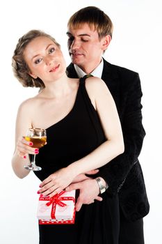 Portrait of a beautiful young couple with glasses of wine and a gift box with a red bow