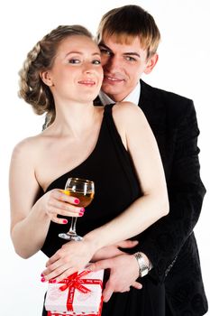 Portrait of a beautiful young couple with glasses of wine and a gift box with a red bow