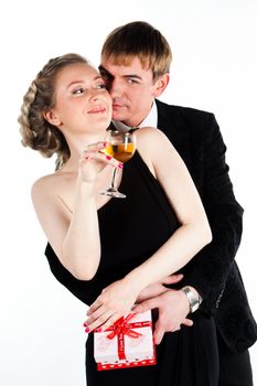 Portrait of a beautiful young couple with glasses of wine and a gift box with a red bow