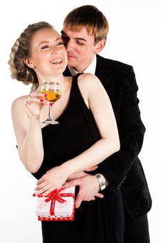 Portrait of a beautiful young couple with glasses of wine and a gift box with a red bow