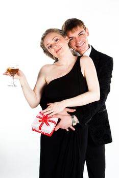Portrait of a beautiful young couple with glasses of wine and a gift box with a red bow
