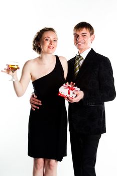 Portrait of a beautiful young couple with glasses of wine and a gift box with a red bow