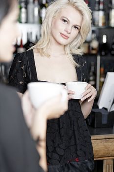 Beautiful young woman talking over coffee at a wine bar.