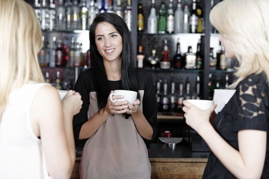 Beautiful young woman talking over coffee at a wine bar.