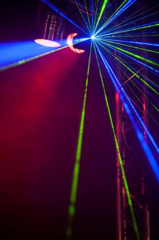 Laser lights and smoke on a dance floor in a nightclub.
