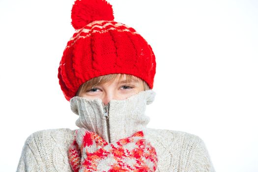 Portrait of young smiling cute frozen teenager in a red hat and mittens, isolated on white