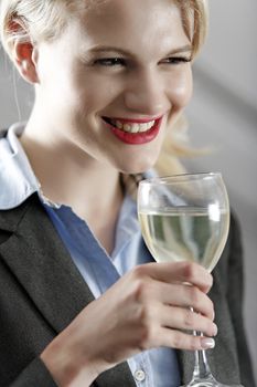 Young woman enjoying a glass of wine after work.