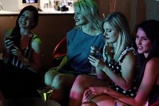 Attractive group of friends laughing and having fun in a nightclub