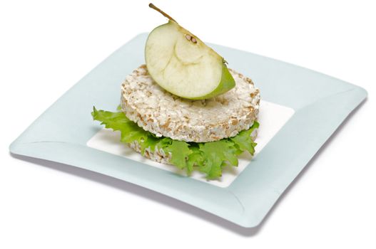 Gramineae Crispbread with Salad leaves and apple isolated on blue plate