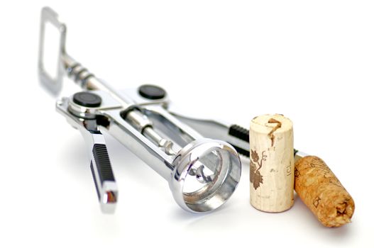 Corkscrew and two wine corks isolated on white background