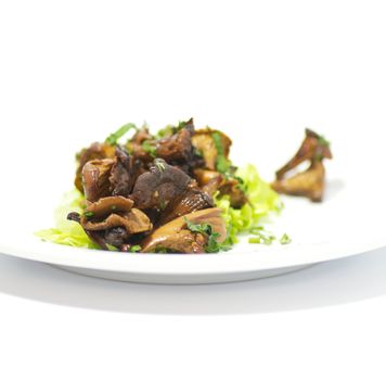 Chanterelles mushrooms with salad leaves isolated on white background