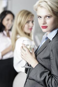 Beautiful young women enjoying a glass of wine after work at a bar.