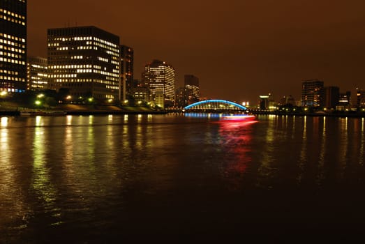 night city view: Sumida-river and Eitai bridge with moving ship in Tokyo, Japan