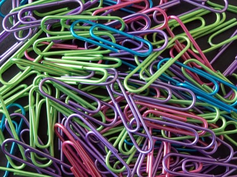 Close-up of lots of multicoloured paper clips .