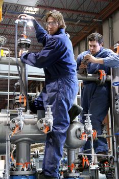 Two machanic working on machinery